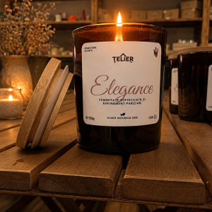 Lumânare parfumată Elegance din ceară de soia, în recipient chihlimbar, aprinsă pe fundal cald și elegant.